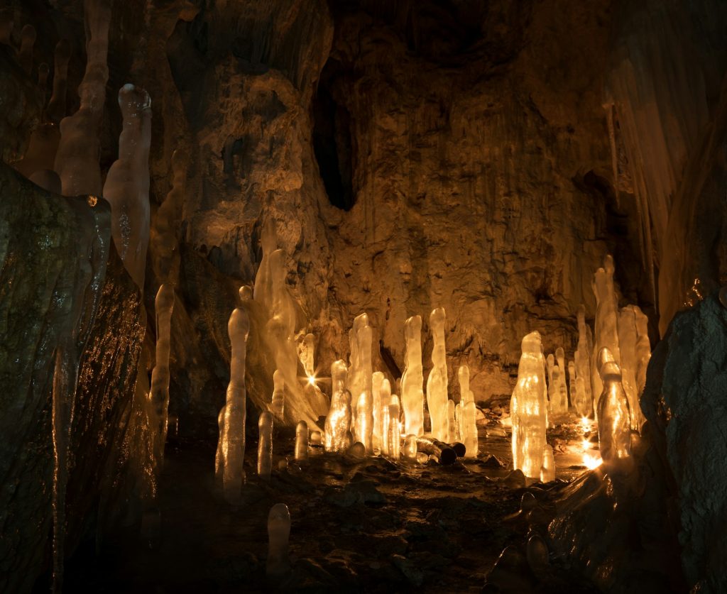 Ice stalagmites in a cave illuminated by candles
